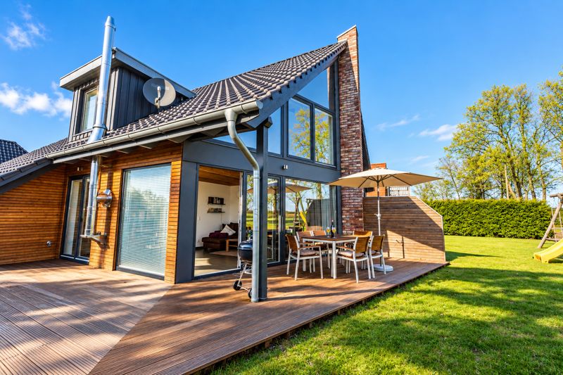 Gartenseite von Thea mit großer Holzterrasse und Glasfront